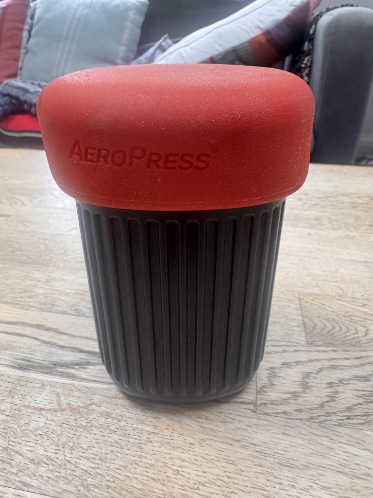 AeroPress Go packed for travel in its mug with red silicone lid
